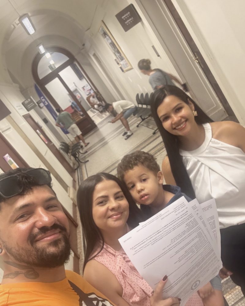 Clientes da assessoria segurando a documentação aprovada