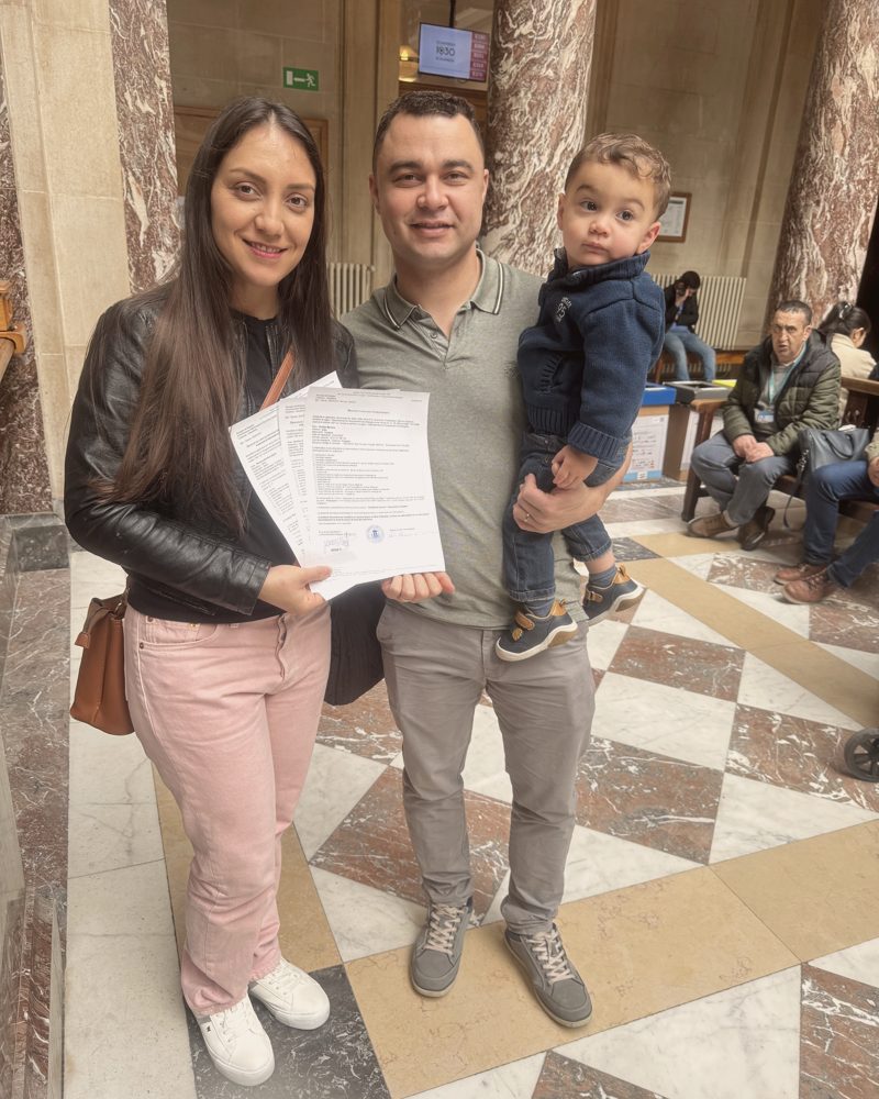 Clientes da assessoria segurando a documentação aprovada